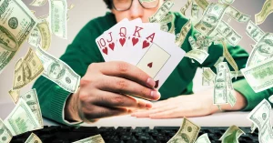 person holding playing cards with money falling around them